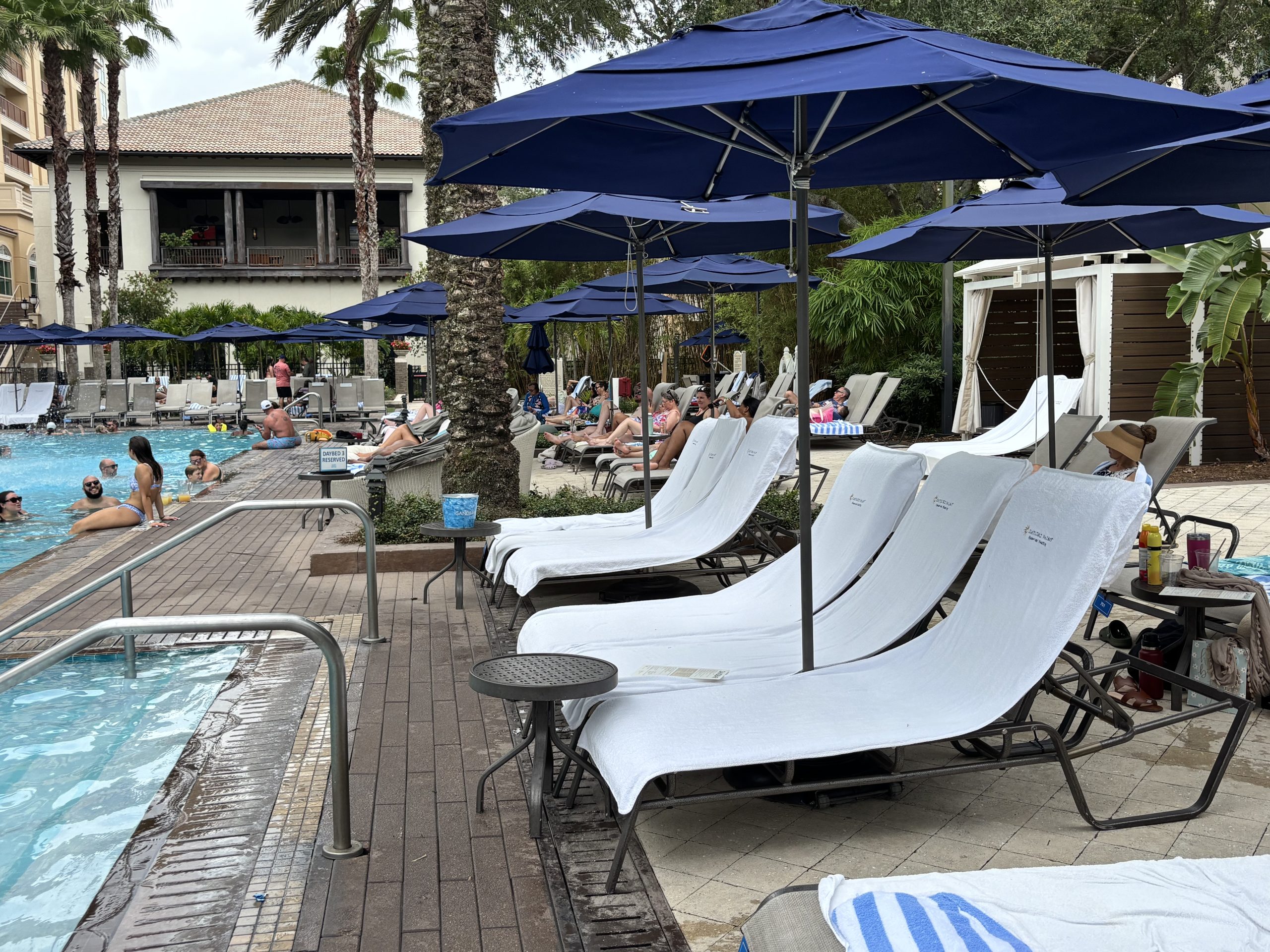 Gaylord Palms Resort & Convention Center Pool area with outdoor seats and blue umbrellas