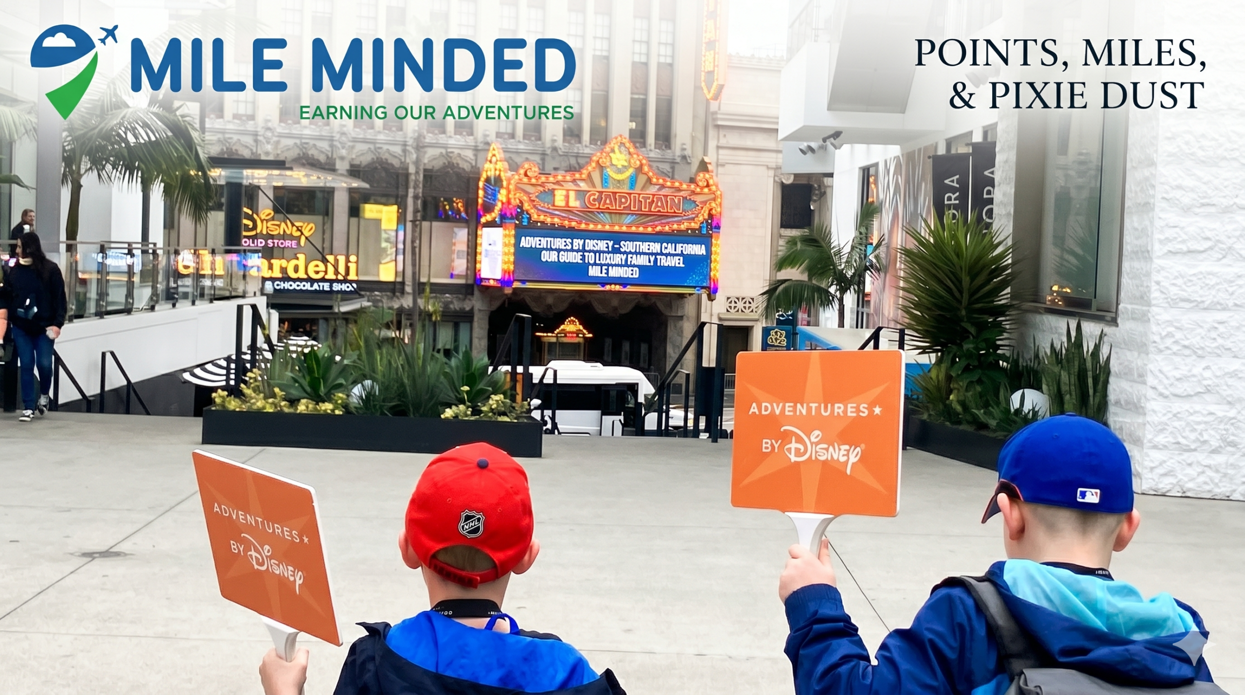Two boys holding signs in front of a theater